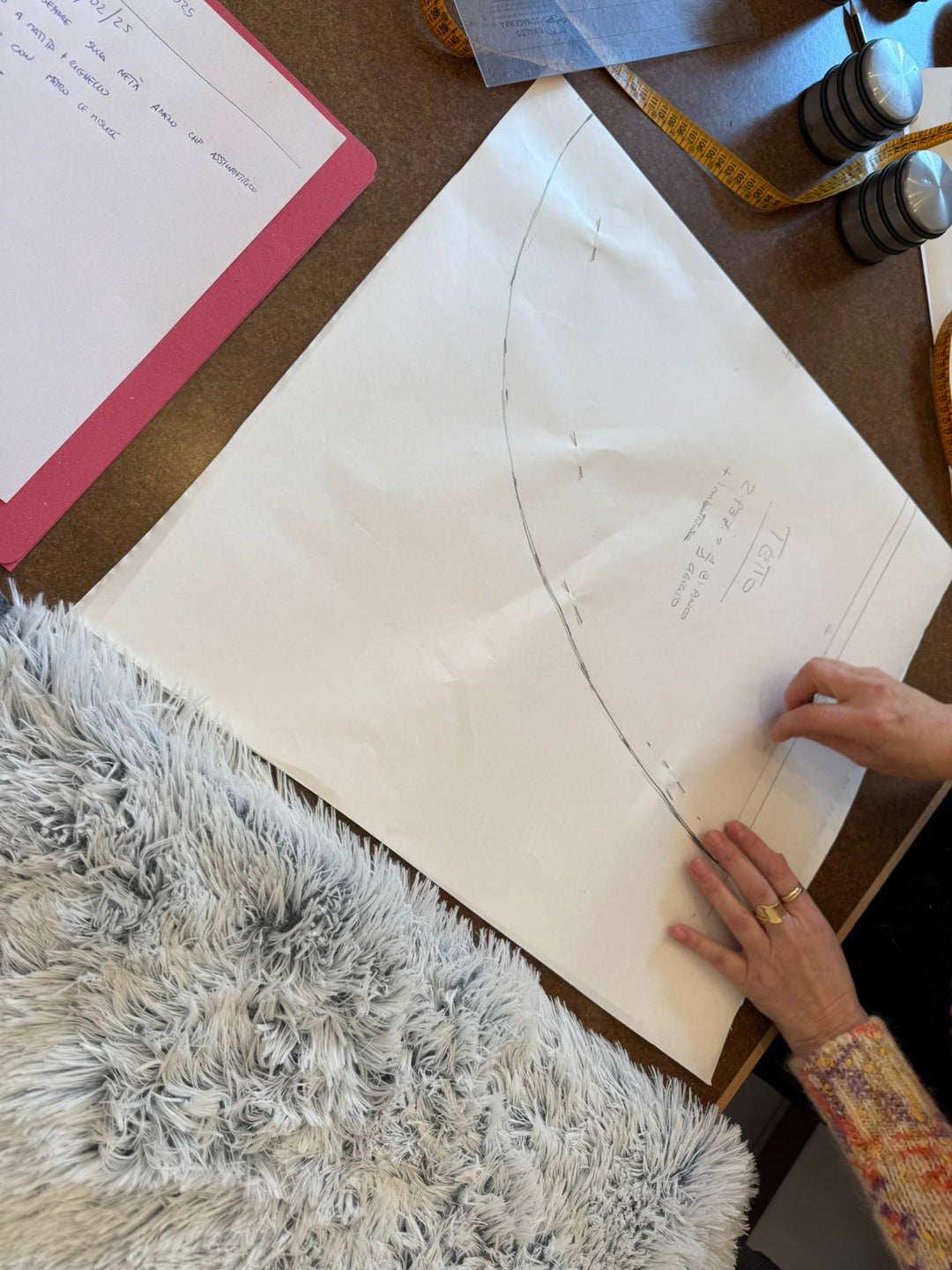 Die Hände der Lehrerin bei der Arbeit am Schnittmuster